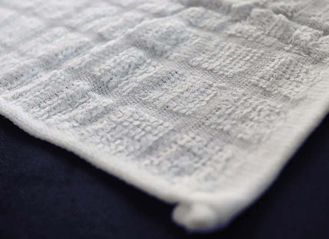 Close up of the Cotton Premier 15 towel's cotton weave and hemmed edge
