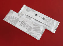 Load image into Gallery viewer, silver Xceed Towels refresher towel on red background