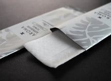 Load image into Gallery viewer, silver Xceed Towels refresher towel on black background with package open