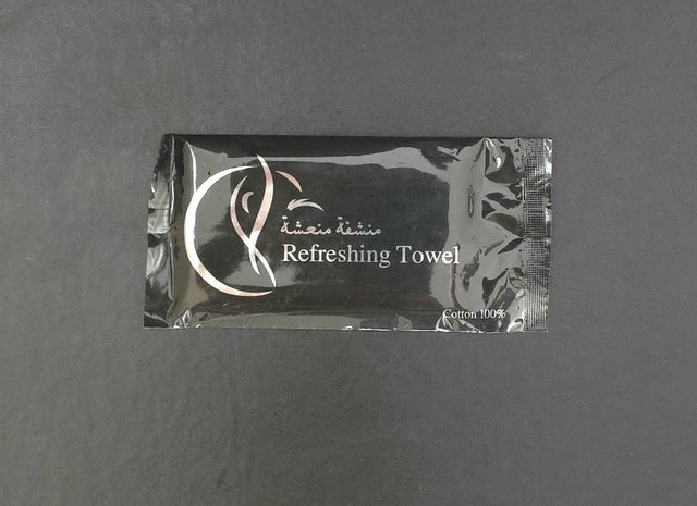 Black refreshing-towel wrapper printed in silver, in English and Arabic